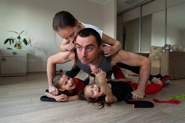 Wall Mural - Father doing workout and funny children having fun and playing with him