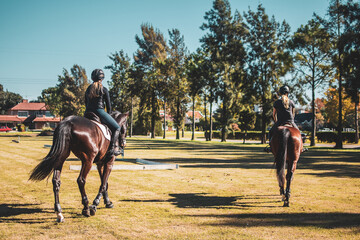 two women riding back to back towards the competition