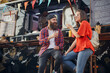 © luckybusiness - caucasian couple talking, smiling, drinking in front of modified truck for fast food service