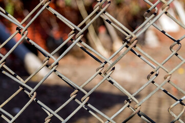 Close-up metal grill fence netting. Chain Link Fence with wild background