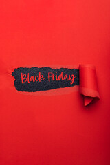 Wall Mural - Black Friday text in paper hole. Red torn paper with black paper as background