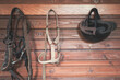 Horse riding concept items, helmet and bridle hangs on a wooden wall