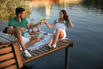 Sticker - Couple clinking glasses with wine on pier at picnic