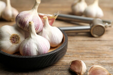 Fresh Organic Garlic In Bowl On Wooden Table, Closeup