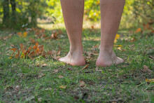 The Guy Walks Barefoot On The Autumn Grass And Leaves