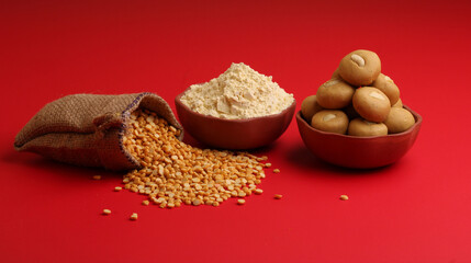 in bowl  Besan sweet Laddu or laddoo along with Chick pea flour or powder and split Bengal gram lentil.