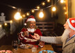© Alessandro Biascioli - Happy multiracial senior friends toasting with red wine glasses during Christmas holidays dinner celebration on patio house party