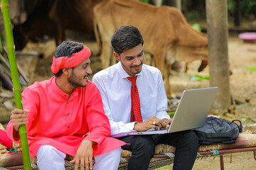 Poster - Young indian agronomist showing some information to farmer in laptop at home