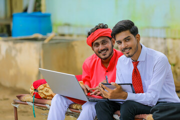 Wall Mural - Young indian farmer and agronomist or banker discuss at home