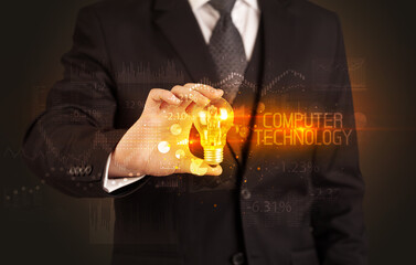 Businessman holding lightbulb with COMPUTER TECHNOLOGY inscription, Business technology concept