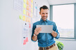© baranq - Smiling businessman using digital tablet standing at office
