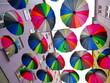 Kolorowe parasolki zawieszone między blokami wysoko nad głową