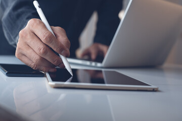 Poster - business man using stylus pen signing on digital tablet working on laptop computer on office desk