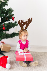 Wall Mural - Baby holding Christmas gift. Winter holidays concept.