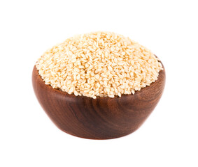 Sesame seeds in wooden bowl, isolated on white background. Organic dry sesame seeds.