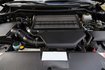 Poster - Front engine compartment of an old Japanese car with clean components and assemblies plastic housing under an open hood top view of the car after preparation for sale.