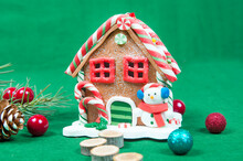 Christmas House With Snowman, Spruce Branch, Red Lights, Cone, On A Green Background Close-up