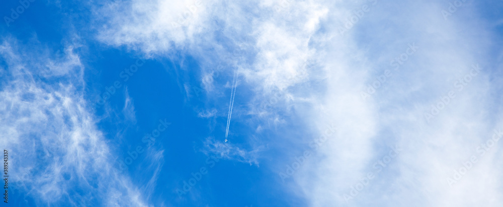 airplane in the blue sky with clouds from below, high flying passenger ...