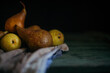 Fresh organic pear fruits on wooden table in dark space. Shallow depth of field