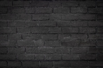  Black color brick wall textured background with vignette at the edge of picture and an empty space for text.