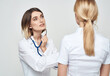 © SHOTPRIME STUDIO - A nurse doctor in a medical gown explains something to a patient in a white T-shirt