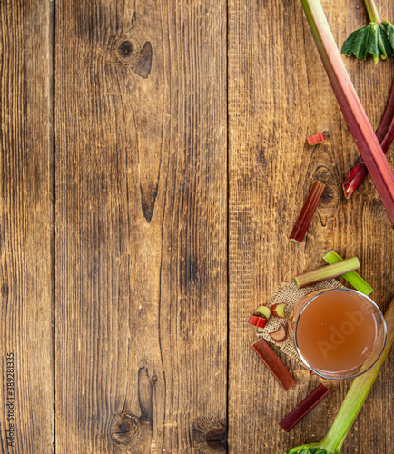 Rhubarb Juice on rustic background (close up; selective focus)