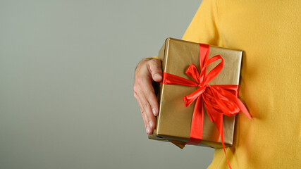 A man holding a gift box with a red bow