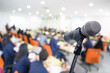 © nattanan - Blurred background Microphone in conference hall or seminar room with business people.