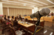 © nattanan - Blurred background Microphone in conference hall or seminar room with business people.