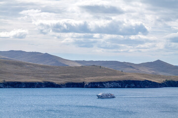 A boat in the middle of Baikal lake with the mountains at the back