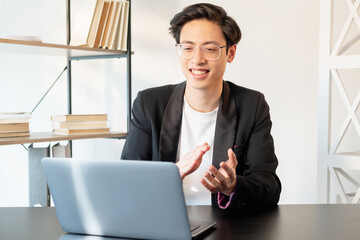 Successful project. Online presentation. Business videochat. Goal achievement. Proud satisfied cheerful asian male manager in glasses applauding on laptop camera at light workplace.