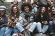 © Alessandro Biascioli - Young people using mobile smartphone outdoor - Millennial friends having fun with new technology social network apps - Youth generation and tech concept