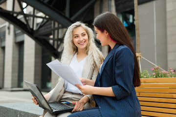 two beautiful young women in suits with laptop