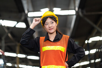 Wall Mural - Woman worker wearing safety goggles at Metal lathe industrial manufacturing factory. portrait of cheerful young Asian woman wearing hardhat smiling happily looking at camera