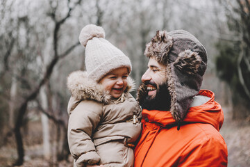 Canvas Print - Handsome young dad and his little sweet daughter have fun outdoors in winter. Happy family spending time together. Family concept.