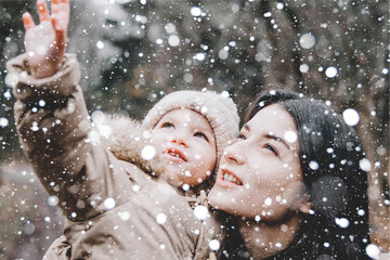 Canvas Print - Beautiful young mom and her little cute daughter have fun outdoors in winter. Happiness to spend time together. Family concept.