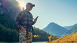 © avtk - hiker men using smart phone in the mountains in the countryside