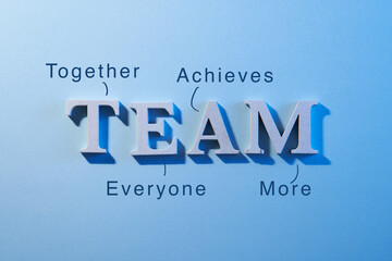 close up of aphabet Team on blue background  ,  together everyone achieves more