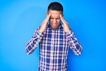 Wall Mural - Young handsome latin man wearing casual clothes with hand on head for pain in head because stress. suffering migraine.