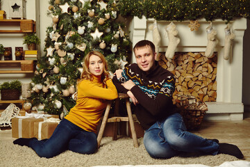 young couple celebrating Christmas at home. man and woman on New Year Eve.