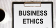 © Veranika - Text BUSINESS ETHICS, a number of accounting reports and a mug of coffee.