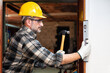 © francescomou - Carpenter worker at work with hammer and spirit level, repairs and installs the door frame of a room. Construction industry. Carpentry.