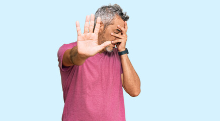 Sticker - Middle age grey-haired man wearing casual clothes covering eyes with hands and doing stop gesture with sad and fear expression. embarrassed and negative concept.