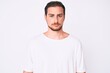 © Krakenimages.com - Young handsome man wearing casual white tshirt skeptic and nervous, frowning upset because of problem. negative person.