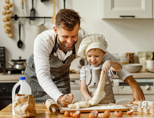 Wall Mural - Father and little boy kneading dough together.