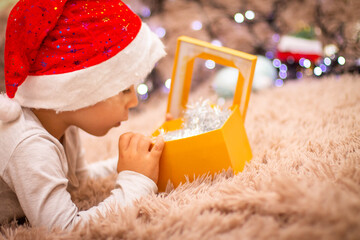 Wall Mural - child in santa claus hat surprised at gifts