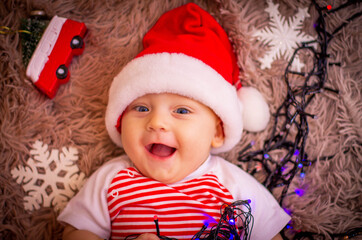 Wall Mural - baby in santa claus hat with Christmas toys.