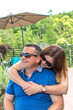 Loving couple smile and hug with sunglasses having a perfect romantic fish dinner on beautiful terace