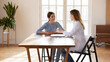 © fizkes - Attentive woman patient sitting at desk at doctor office listening to recommendations of female GP or counsel of psychologist, medical advisor proposing regular insurance policy to interested customer