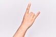 © Krakenimages.com - Close up of hand of young caucasian man over isolated background gesturing rock and roll symbol, showing obscene horns gesture